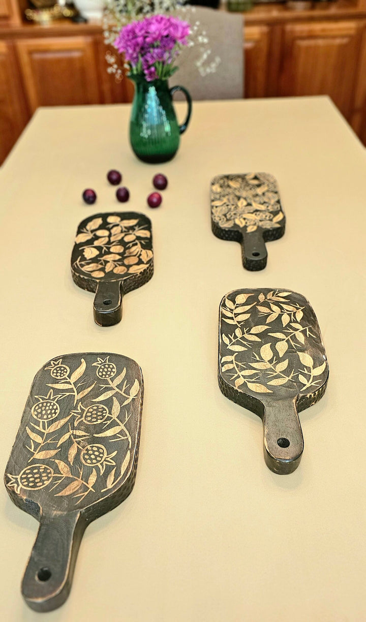 Decorative cutting boards with engraved designs on a kitchen counter.