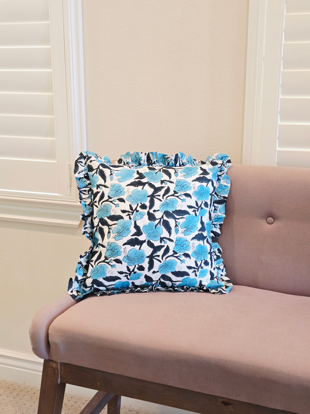 Person wearing blue floral patterned boxer briefs in a neutral setting.