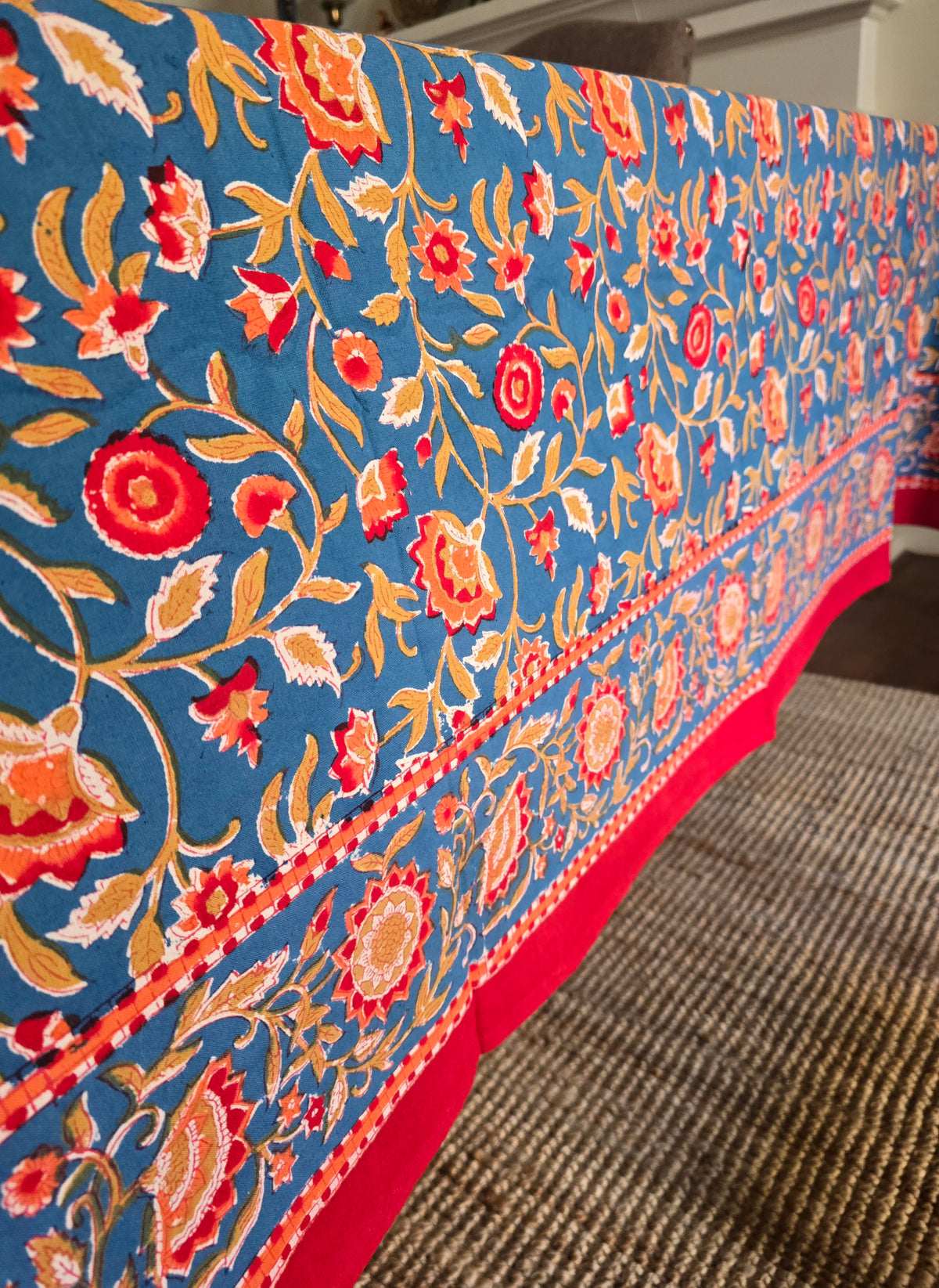 Floral patterned tablecloth on a table with a blue background