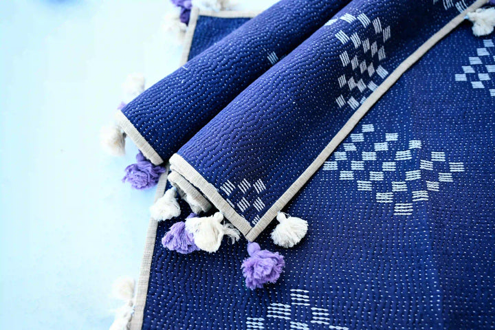 Close-up of hand-stitched kantha embroidery on cotton placemat