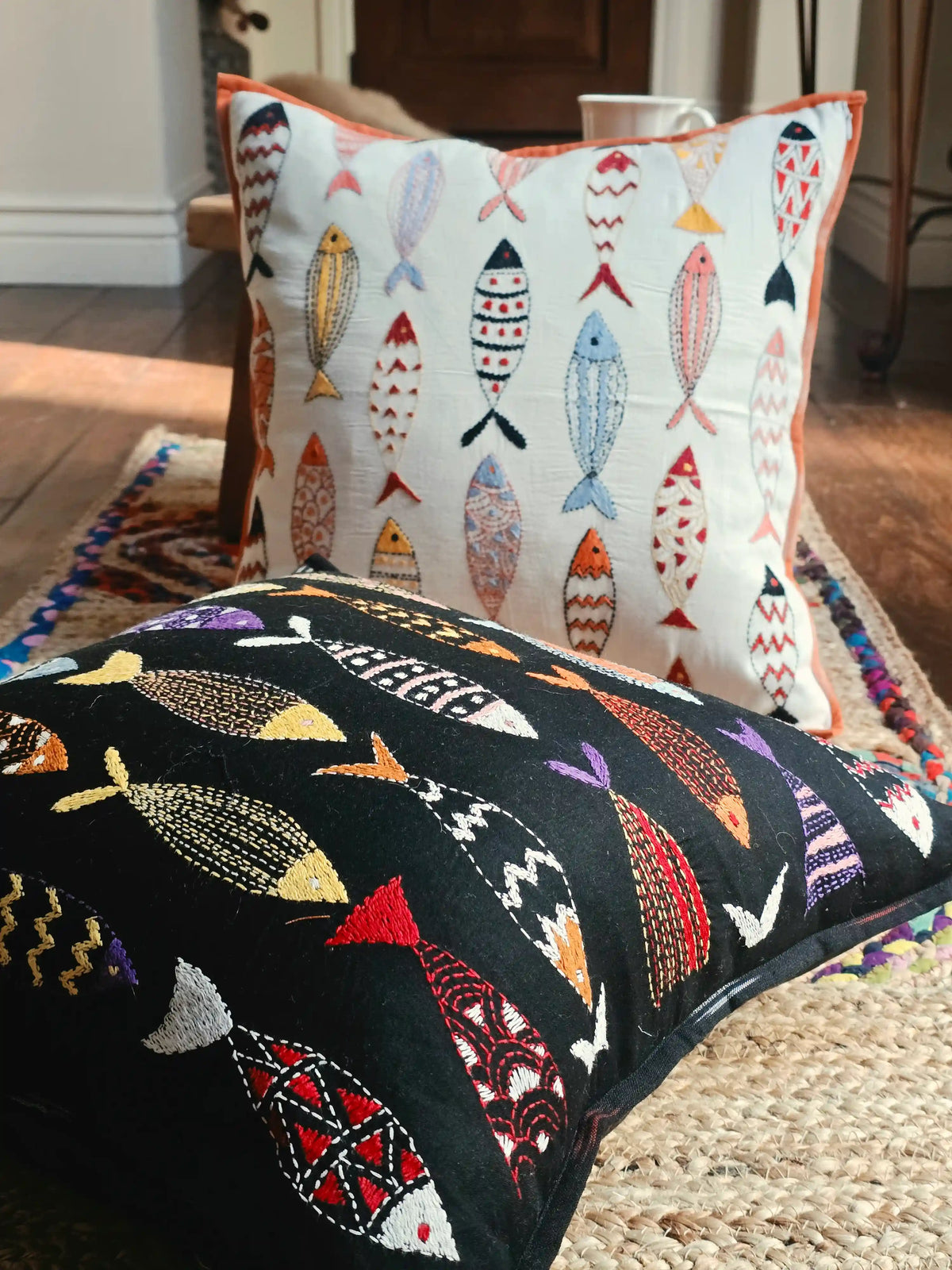 Close-up of hand-stitched fish motif embroidery on cushion cover