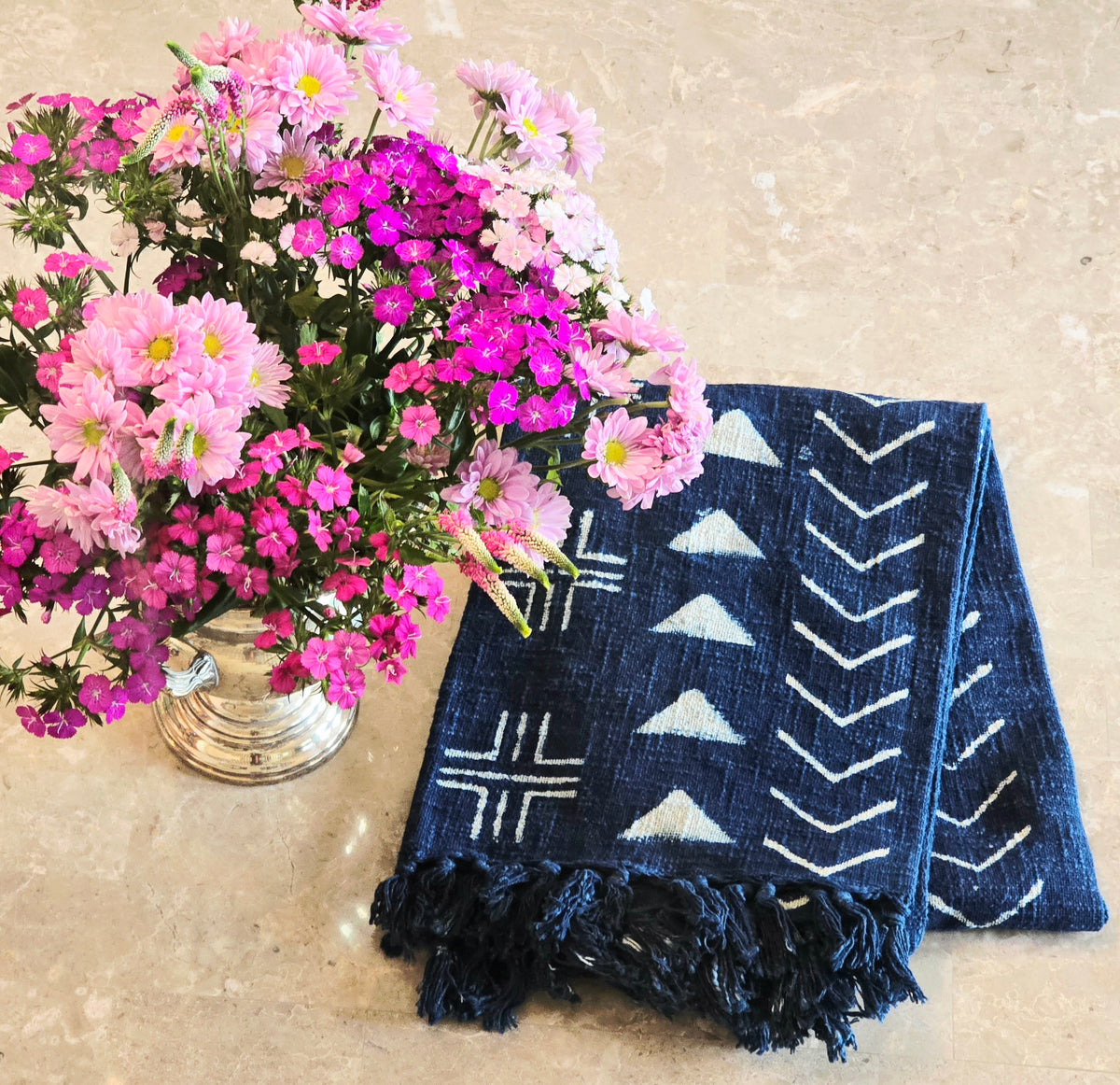 Navy blue indigo throw with white patterns on a beige surface