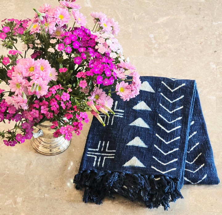 Navy blue indigo throw with white patterns on a beige surface