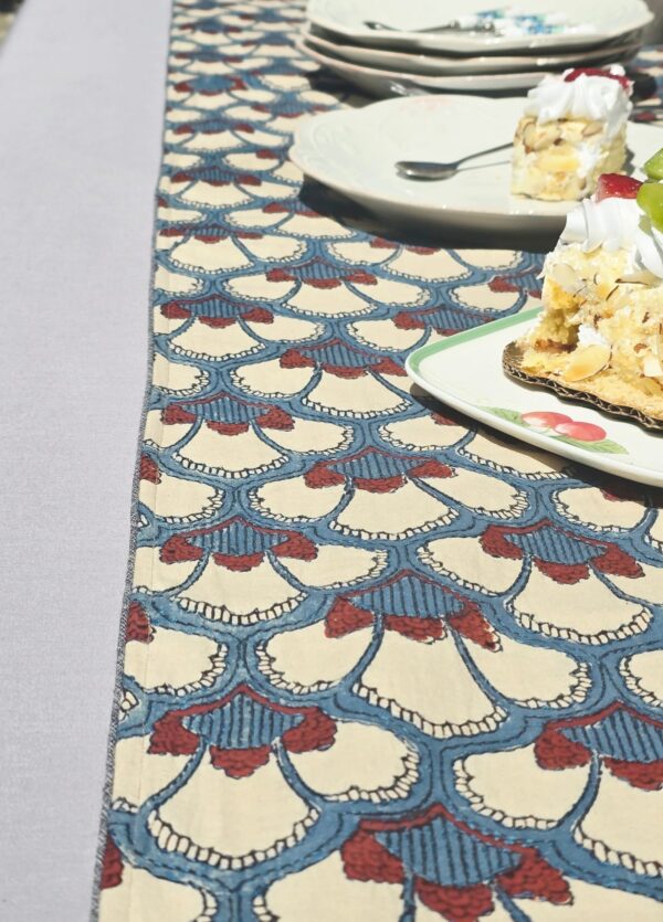 Hand block printed multicolor embroidered cotton table runner on outdoor dining table with floral centerpiece