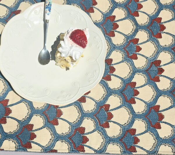 Hand block printed multicolor embroidered cotton table runner on outdoor dining table with floral centerpiece